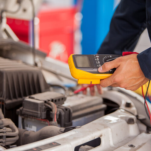 mechanic testing a car's battery