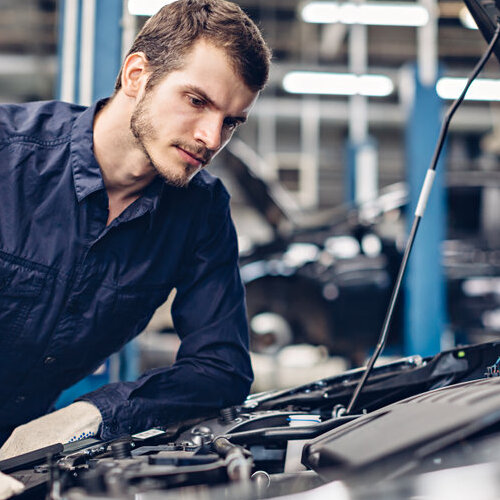 Mechanic examining a car engine.